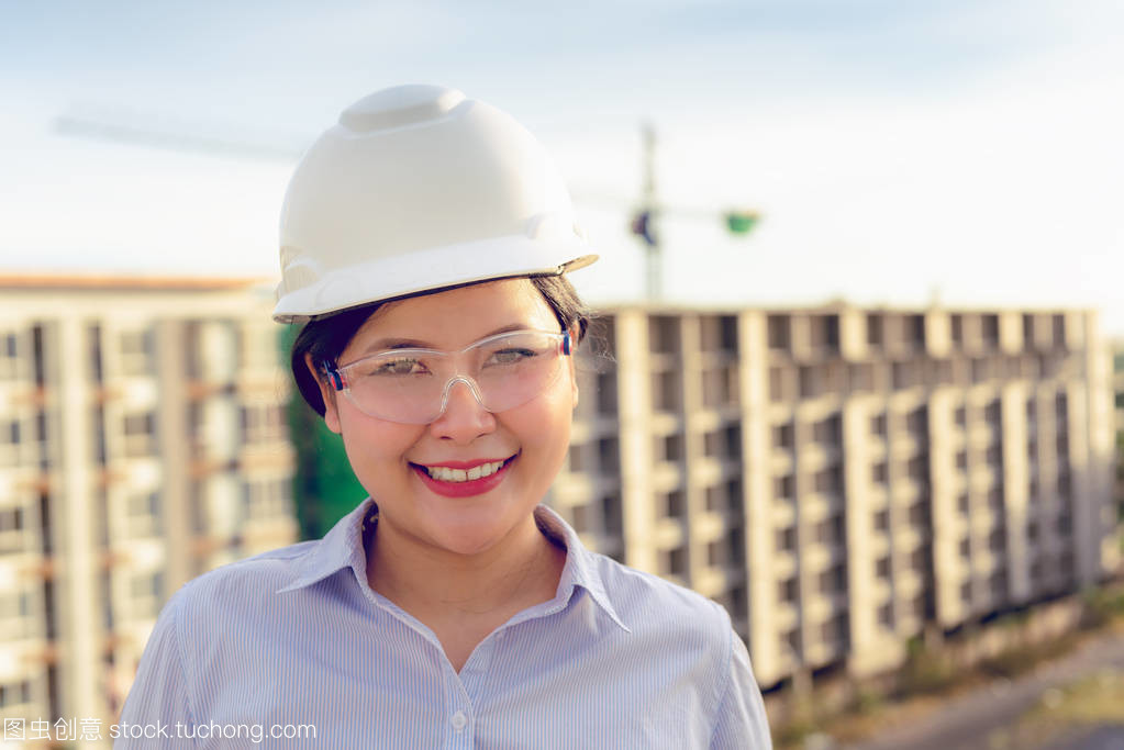 日落背景后建筑工地前土建工程女人員的特寫畫像